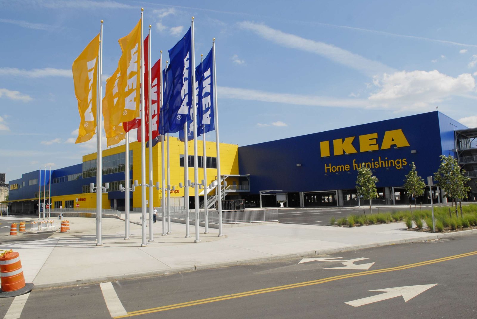 IKEA Delivery Service Location IKEA store building with colorful flags flying at the front, showcasing the brand’s blue and yellow colors.